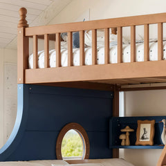 Close-up of the wooden upper bunk railing and round porthole window side panel