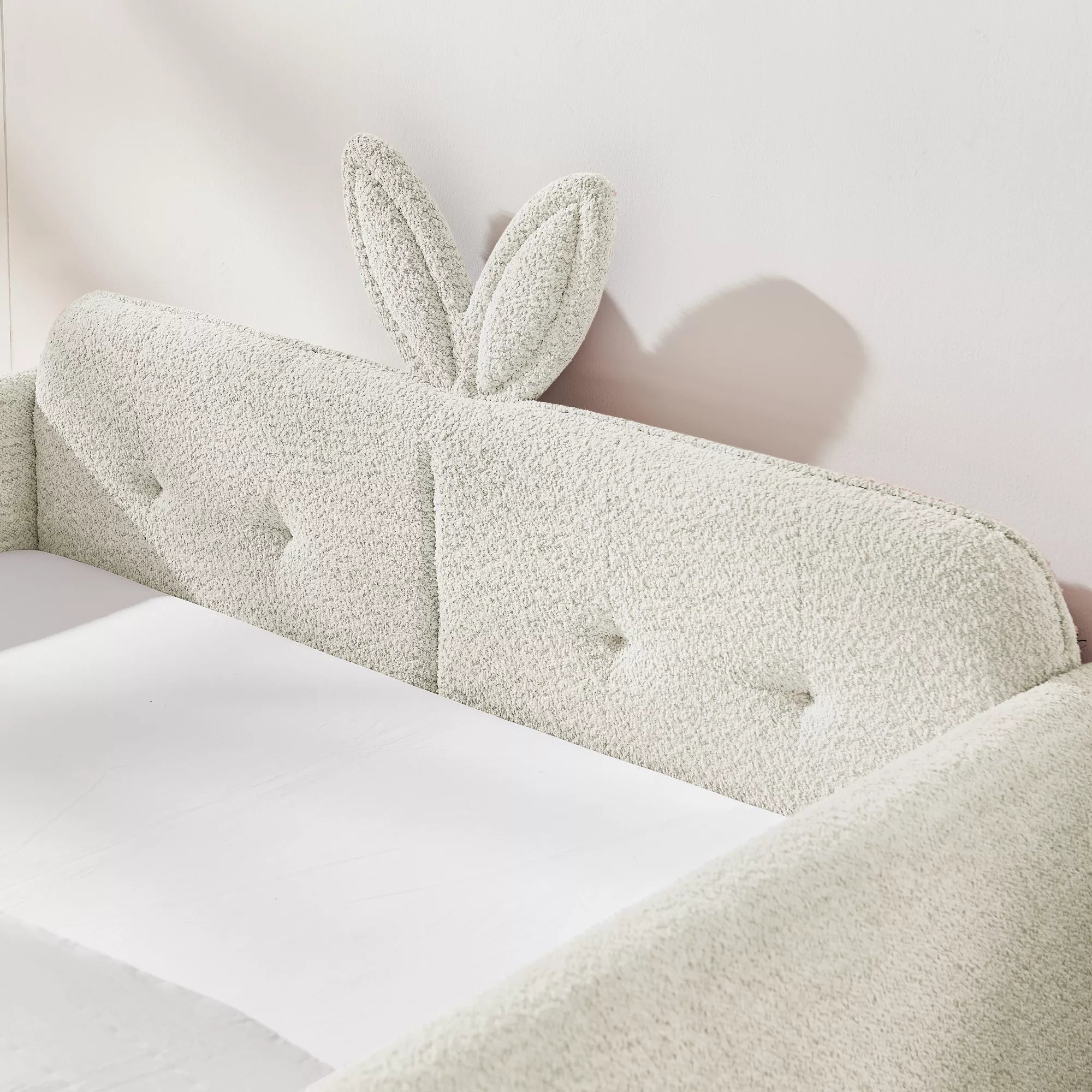 Cute 3D bunny ear tufted headboard close‑up, boucle upholstered full size kids bed headboard detail, cream white