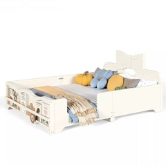 White wooden kids platform bed with bow headboard, safety guardrails and footboard book storage shelf, decorated with pillows and blankets