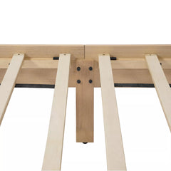 Underside of the wooden bed frame showing the slat support area and central support