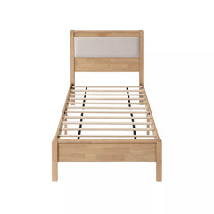 Wooden bed frame viewed from the foot end, showing the plywood slats
