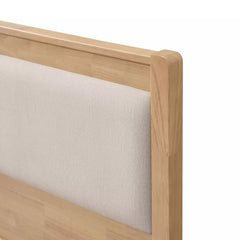 Close-up of the upholstered headboard panel framed by wood