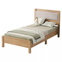 Assembled natural wood bed with upholstered headboard and mattress, three-quarter view