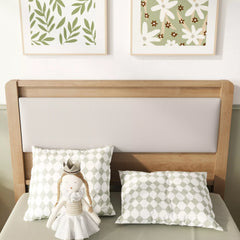 Close-up of the upholstered headboard and pillows on the wooden bed