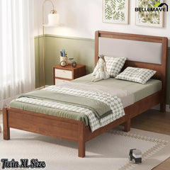 Brown Twin XL wooden bed with upholstered headboard in a bedroom, three-quarter view